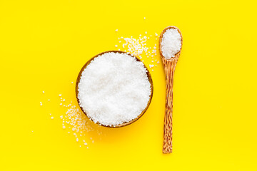 Coarse sea salt in a wooden and spoon, top view. Salt for spa, salt baths or cooking