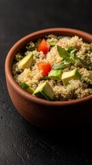 Cozy table setting with a warm bowl of quinoa salad featuring sliced avocado and cherry tomatoes in bright colors
