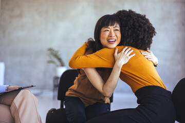 Two Diverse Women Embracing Each Other During a Support Group Session