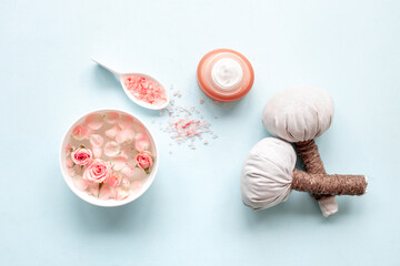 Roses essence water in bowl with petals and skin care cosmetic products with flowers essential oil