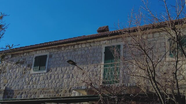 Cold sunny morning in the village or city. Stone house is heated in cold winter and smoke comes and pipes on the roof of the house