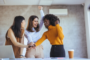 Three Women Cheering and Celebrating Success in a Business Meeting