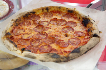 Tasty fresh pizza with sausage and cheese on the counter