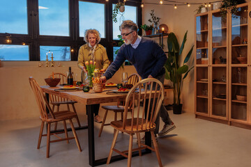 Senior couple preparing dinner table for pension celebration
