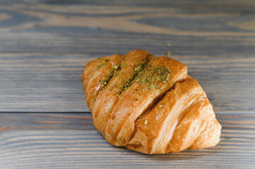 fresh baked croissant isolated on a wooden background