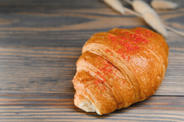 fresh baked croissant isolated on a wooden background