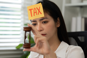 Time management in tax preparation. Businesswoman reviewing tax documents with an emphasis on urgency via visible sticky note.