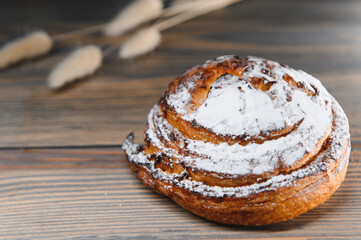 Sweet cinnamon bun roll swirl on a wooden background