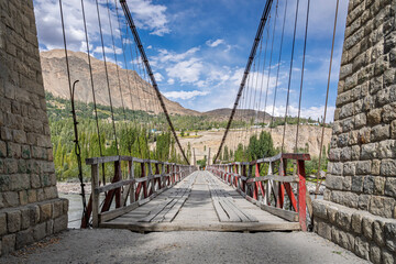 Scenic frontal view of ancient wooden suspension bridge over Shyok river near Khaplu, Ghanche, Gilgit-Baltistan, Pakistan