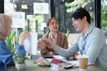 Workplace Collaboration and Green Initiatives. Team members sharing ideas for sustainable development at their eco-conscious office.