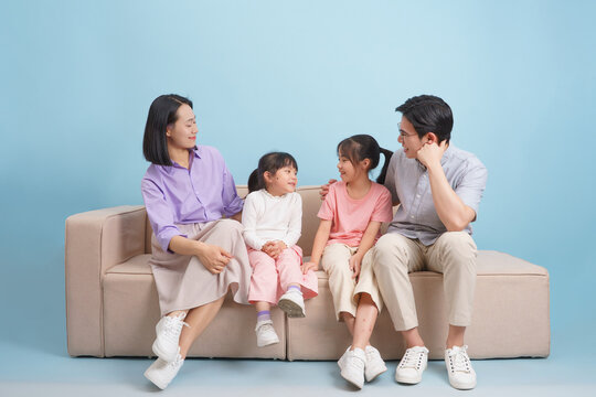 Family enjoying quality time together on a couch with a blue background in a cozy living room setting