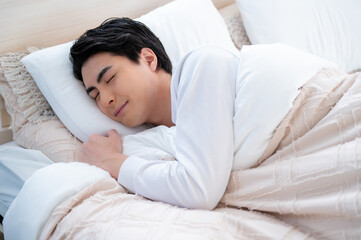 ベッドで眠る日本人男性
