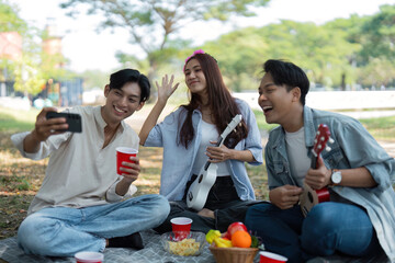 Friends taking selfies during a joyful picnic in the park