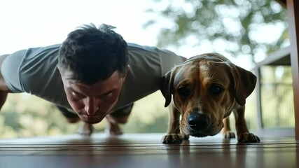 Man doing push-ups on a porch with a dog playfully nudging him