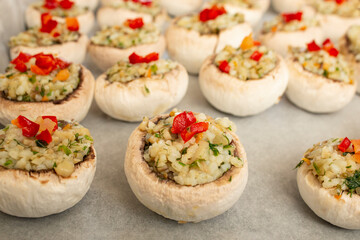 Stuffed champignon mushrooms with rice, parsley and pepper on a sheet of baking paper
