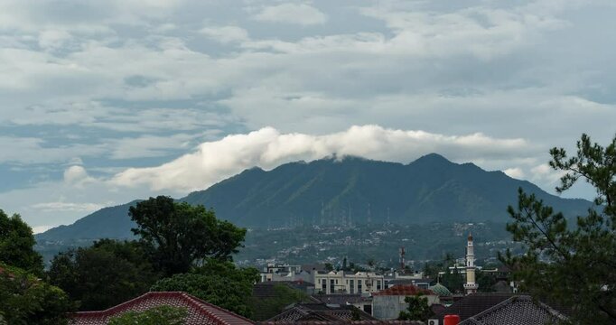 Timelapse of clouds rolling over the mountain top in the afternoon in Bandung, Indonesia