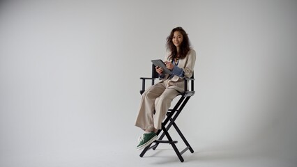 A Professional Female Model, Elegantly Dressed in a Chic Suit, While Skillfully Holding a Clipboard