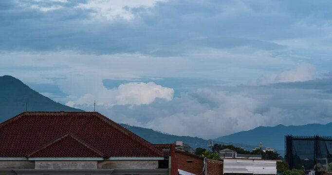 Timelapse of clouds rolling behind the mountains in the afternoon in Bandung, Indonesia