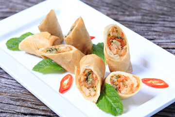 Crispy prawn spring rolls. Crispy prawn spring rolls on white plate, Decorate with mint leaves and chili peppers
