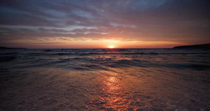 Beautiful dramatic sunrise over the sea waves and beach shore