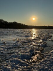 Ice Age far away at the Arctic pole in the snowy mountains in winter. Global warming and melting transparent blocks of ice. Spring atmosphere on a river or lake
