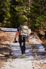 Naklejka premium Photographer hiking through snowy forest........
