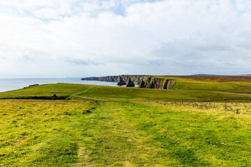 Duncansby Stacks, a breathtaking coastal wonder in Scotland, rise from the North Sea. Standing atop...