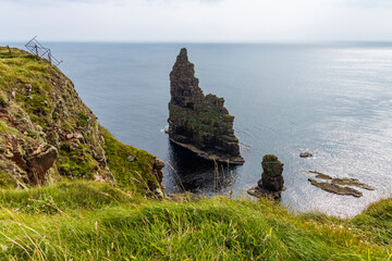 Duncansby Stacks, a breathtaking coastal wonder in Scotland, rise from the North Sea. Standing atop...