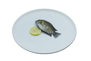 Tilapia Fish Served with a Fresh Lemon Slice on a White Plate – Isolated on a Clean White...