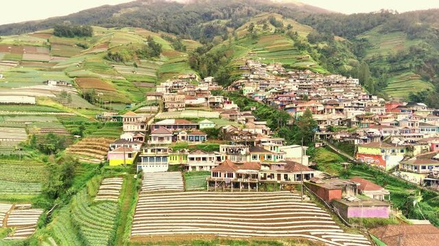 view of village on the lush mountain slope called Dusun Butuh surrounded by agricultural fields