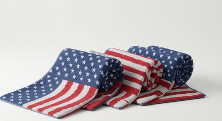 Obraz premium Rolled Patterned Towels Displaying Stars and Stripes Design on Neutral Background