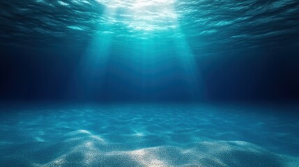 Fototapeta premium Underwater Scene with Sunlight Penetrating Blue Ocean Surface and Sandy Seabed
