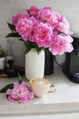 Cup with cappuccino, flowers peony, morning concept, woman's day