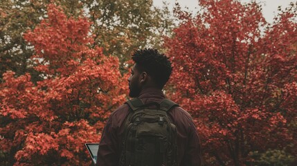 A black man sits at his laptop, reviewing his investments with a determined look