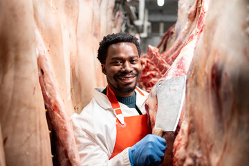 Portrait of experienced butcher with sharp knife working in slaughterhouse meat food factory.