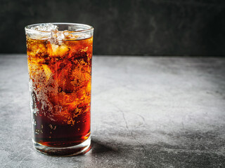 Cola soft drink with ice cubes, soda pop fizzy drink in Cold glass on gray background