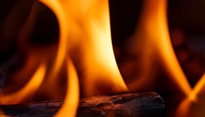 Macro view of a burning flame; a close up view of a fire burning; up and close view of a bonfire burning in a wood pit crackling and amber flying; orange and yellow flame is burning in a fire pit; 