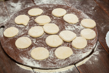 Circles of cookie dough on a table sprinkled with flour