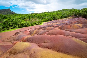 Scenic and beautiful view of amazingly colorful eroded dunes in a tropical jungle clearing at the Seven Colored Earth Geopark in Chamarel, Mauritius