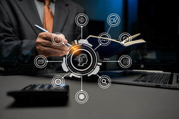 Agile development methodology concept. Business hand using laptop computer and tablet with virtual screen agile icon on modern office digital technology concept.