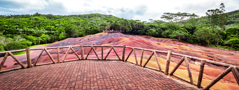 Scenic and beautiful view of amazingly colorful eroded dunes in a tropical jungle clearing at the Seven Colored Earth Geopark in Chamarel, Mauritius