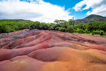 Scenic and beautiful view of amazingly colorful eroded dunes in a tropical jungle clearing at the Seven Colored Earth Geopark in Chamarel, Mauritius