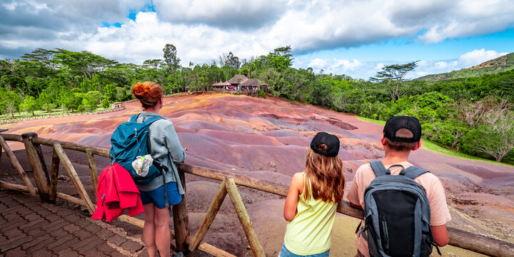 View of a mother with two children looking at the amazingly eroded colorful dunes at the Seven Colored Earth Geopark in Chamarel, Mauritius