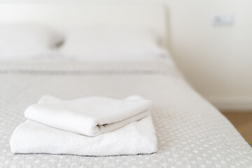 Cozy and inviting bedroom setup with neatly arranged towels on the bed