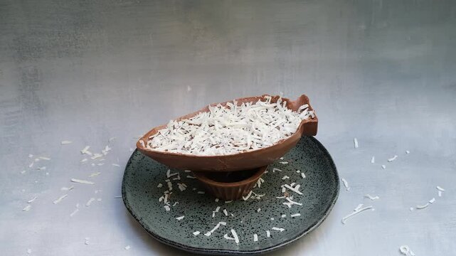 Grated coconut falling on a milk chocolate Easter egg.