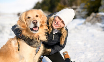 Portrait of woman with healthy golden retriever dog outside in winter season