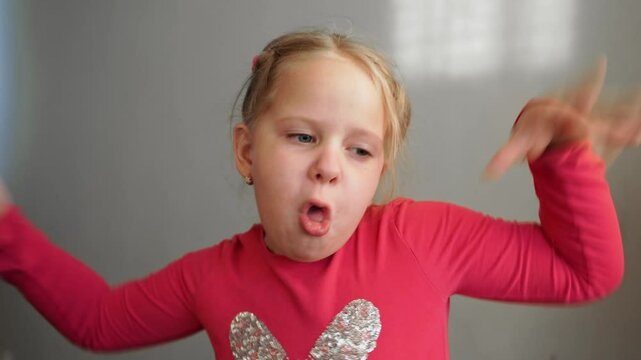 Young girl making a playful and funny face, sticking out her tongue and raising her hands to mimic a long nose. Child expressing humor, mischief, and joy, with a cheeky attitude