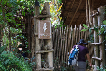 selective focus Wooden sign for women's restroom written in white. A cafe restroom in a deep forest decorated in a shady, natural style with space for text.
