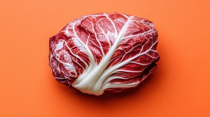 Obraz premium Fresh, vibrant radicchio head on an orange background.