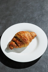 italian whole grain brioche croissant on the white plate on grey store background, Italian breakfast 